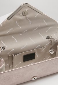 Metallinen roosa kultainen käsilaukku, jossa on teksturoitu pinta. Sisällä on beige vuori, jossa on toistuva logo, vetoketjullinen tasku ja avainnauhaväline.