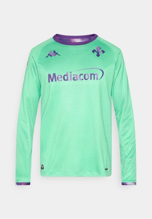 Tricou de fotbal cu mânecă lungă, din material plasă verde mentă, cu accente și logo mov. Are guler rotund și model texturat pe toată suprafața.