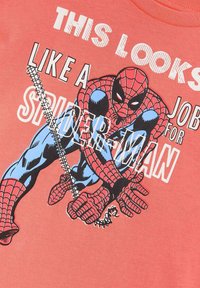 Koraalkleurig T-shirt met een grafisch ontwerp van Spider-Man, afgebeeld in felle kleuren. De tekst luidt: "DIT IS EEN BAANTJE VOOR SPIDER-MAN."