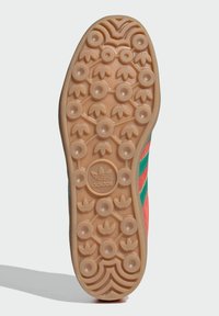 Outsole tenisky Adidas s gumovou podrážkou so zaoblenými trakčnými vzormi, doplnená centrálnym logom a žiarivými, kontrastnými farbami.