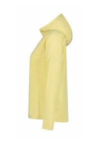Sweat à capuche à manches longues de couleur jaune pâle vu de côté, avec une coupe légèrement ample et une capuche reposant dans le dos.