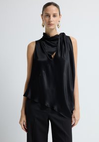 Zwarte satijnen top met een gedrapeerde halslijn en een asymmetrische zoom. Beschikt over een sleutelgatdetail en een gladde, glanzende textuur.