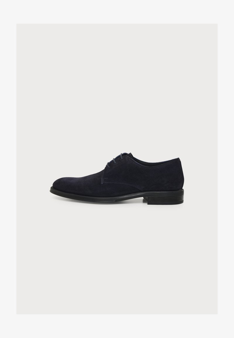 Chaussure de ville en daim bleu marine foncé pour homme avec semelle et lacets noirs, vue de profil sur un fond clair uni.