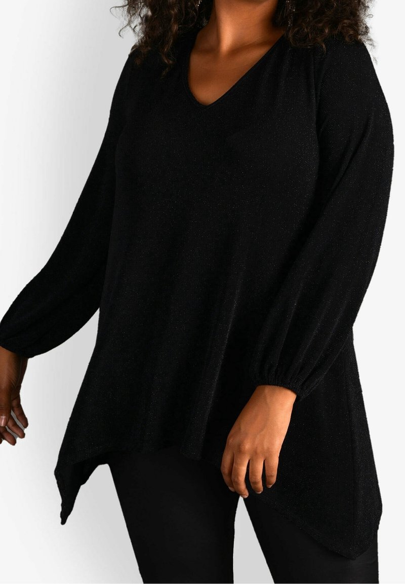 Túnica negra con cuello en V hecha de una tela texturizada con un brillo sutil. Mangas largas y abullonadas. Dobladillo asimétrico con un corte relajado.