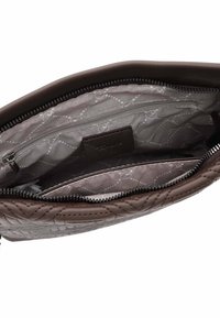 Interno della borsa a tracolla in pelle marrone con rivestimento trapuntato grigio, dotato di tasca con zip e ulteriori scomparti per l'organizzazione.