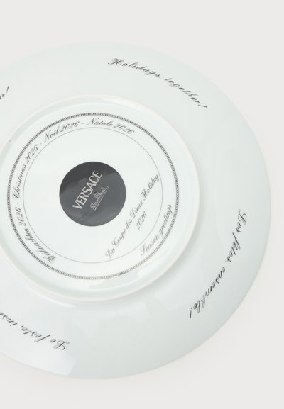 Λευκό πιάτο Versace με χριστουγεννιάτικες ευχές και κείμενο "Χριστούγεννα 2026" σε πολλές γλώσσες γύρω από την περιφέρεια και το κεντρικό λογότυπο.