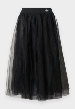 Čierna sukňa z tylu so širokým elastickým pásom s bielym logom. Sukňa má vrstvený dizajn, ktorý vytvára objemný tvar.