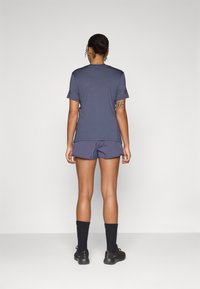 Navy athletic t-shirt with short sleeves and a relaxed fit, paired with navy shorts. Both garments have a smooth texture and casual design.