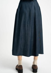 Dżinsowa spódnica w kształcie litery A w ciemnoniebieskim kolorze, z wysokim stanem, bocznymi kieszeniami oraz swobodnym krojem sięgającym do połowy łydki. Miękka tekstura.