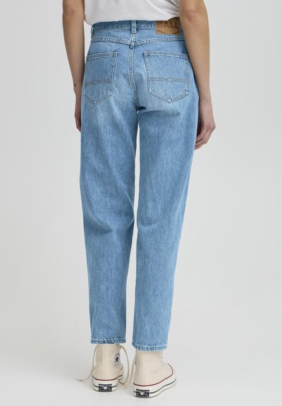 Jeans de mezclilla azul claro con un corte relajado, que presentan bolsillos traseros, costuras decorativas y un parche de cuero con la marca en la cintura.