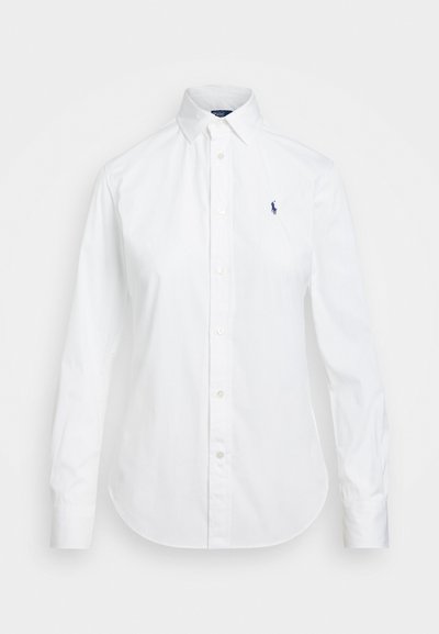 Chemise blanche à boutons avec un col pointu, des manches longues et un petit logo bleu sur la poitrine gauche. Fabriquée en tissu en coton.