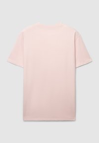 T-shirt di cotone rosa chiaro, maniche corte, scollo rotondo, con un design semplice senza motivi o dettagli. Texture liscia.