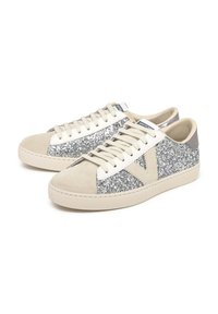 Zapatillas hechas de ante beige con detalles en glitter plateado y acabados en cuero blanco. Presentan punteras redondas, cordones planos y suela de caucho.