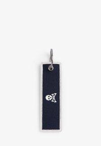 Llavero de tela azul marino con ribete blanco, que presenta un diseño bordado de calavera y tibias cruzadas. Incluye un anillo de metal para la sujeción.