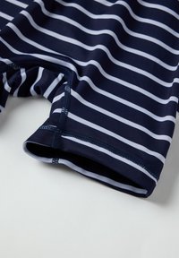 Tummansiniset uima-shortsit, joissa on valkoisia vaakaraitoja. Ne on valmistettu sileästä kankaasta, ja ne istuvat mukavasti. Hieman ommellut saumat lisäävät kestävyttä.