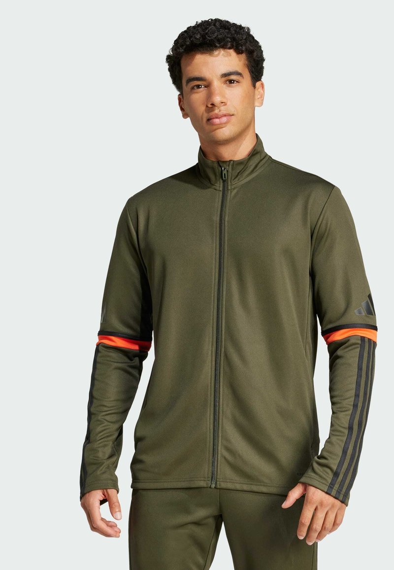Olive green athletic jacket with high collar, front zipper, and black stripes on sleeves, featuring orange accents on cuffs.