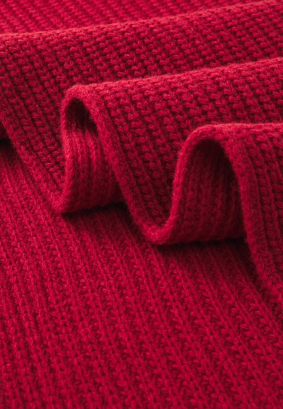 Tessuto a maglia rosso con un motivo a coste testurizzato, che mette in mostra un filato spesso e morbido in una tonalità vibrante e uniforme. Leggermente arricciato ai bordi.