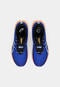 Blå atletiksko med en tekstureret overdel, orange accenter på sålen, sorte snørebånd og en refleksstribe langs siderne.