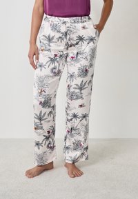 Pantaloni leggeri in crema con un motivo tropicale in nero e grigio, arricchiti da accenti di rosso e rosa. Vita elastica con cordoncino, tasche laterali.