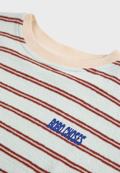 Light blue knit fabric with horizontal red stripes, beige ribbed crew neckline, and blue embroidered text "BOBO CHOSES" on chest.