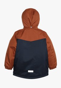 Giacca a cappuccio per bambini con parte superiore e maniche color ruggine, parte inferiore blu navy, polsini elasticizzati e un piccolo riflettente sull'orlo posteriore.