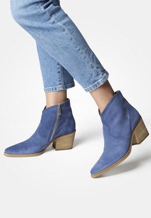 Stivaletti in camoscio blu fino alla caviglia con punta affusolata e zip laterale, caratterizzati da dettagli stampati e un tacco impilato simile al legno.