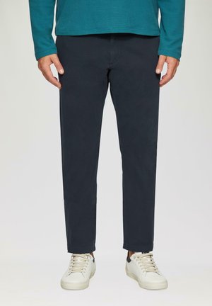 Marineblauwe chinos met een rechte pasvorm, gemaakt van een soepele katoenen stof en subtiele stiksels. Gecombineerd met witte sneakers.