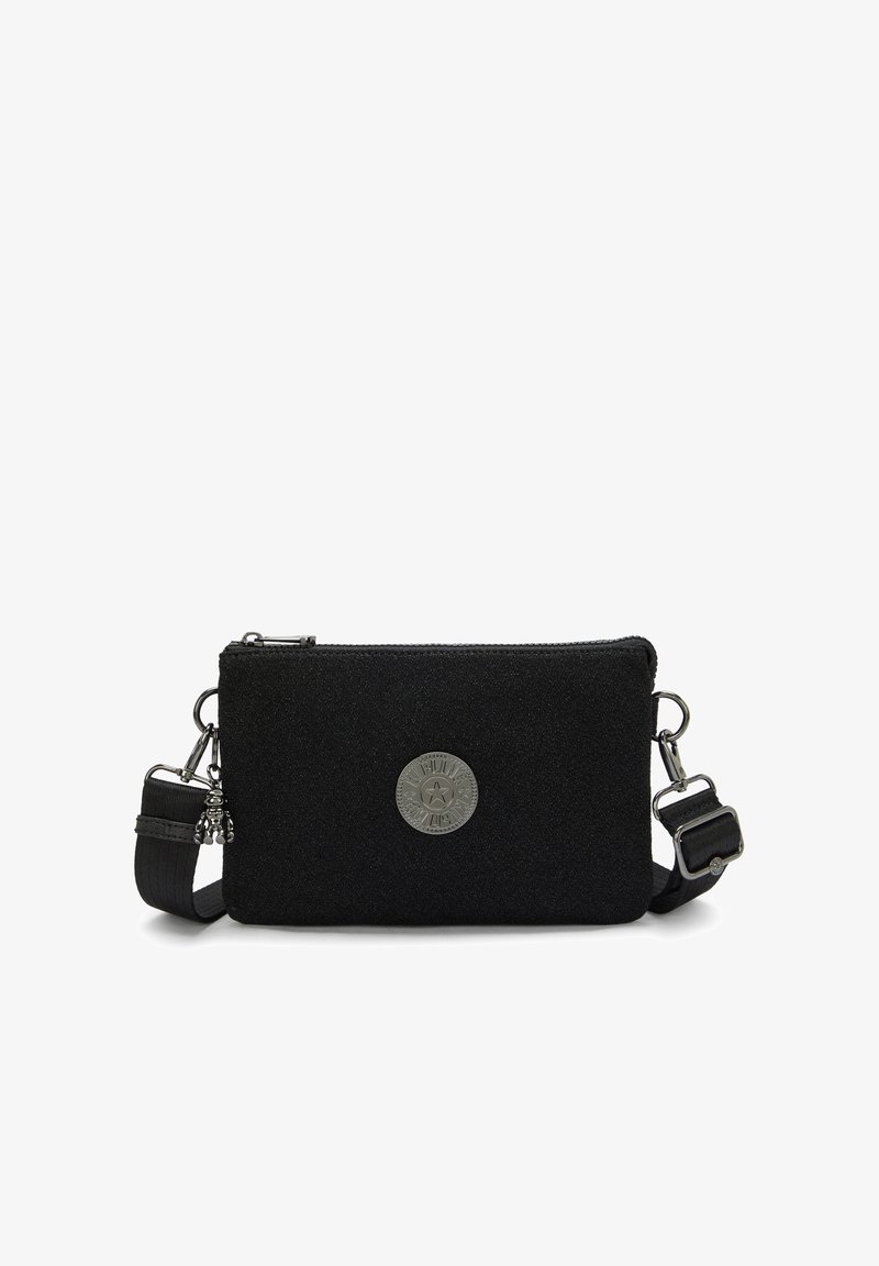 Black textile crossbody bag with a smooth texture, featuring silver hardware, a round logo patch, and an adjustable strap.