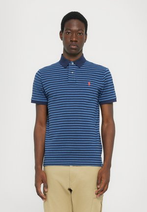 Poloshirt in marineblauw met horizontale blauwe strepen, voorzien van een donkere kraag en een klein rood logo op de linkerkant van de borst. Korte mouwen, gemaakt van katoen.