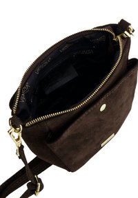 Brun ruskind skuldertaske med gulddetaljer, lynlåslukning, et enkelt hovedrum og en inderfor med logo. Har en yderlomme.