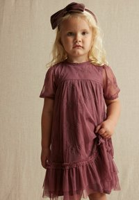 Mädchenkleid in Mauve mit durchsichtigen kurzen Ärmeln, floralem Stickerei, gerafftem Taillenbund und rüschengesäumtem Saum; kombiniert mit einem passenden Haarband mit Schleife.