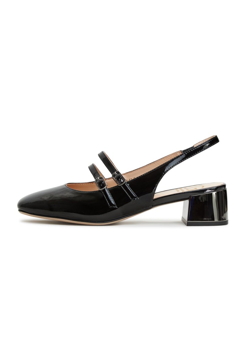 Zapato de charol negro con tirantes decorativos, punta afilada y tacón grueso transparente.