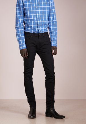 Blue checkered shirt with long sleeves, paired with black skinny jeans and black ankle boots. Simple design, smooth texture.