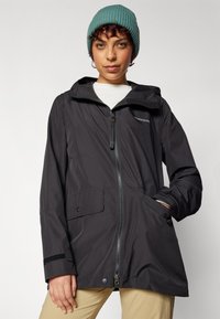 Giacca impermeabile nera con chiusura a zip, cappuccio e tasche frontali. Presenta un design elegante e polsini regolabili per il comfort.