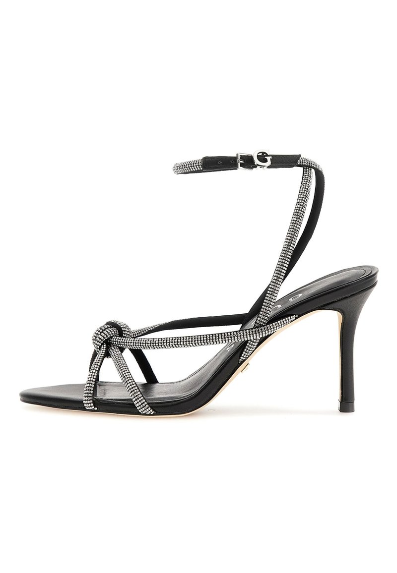 Svarta högklackade sandaletter med knut framtill, strassdetaljer på remmarna och en smal stiletto-klack. Slät textur.