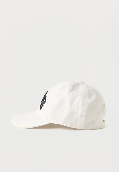 Άσπρο καπέλο μπέιζμπολ με μαύρο κεντητό γράμμα στο μπροστινό μέρος, εμφανίζεται σε απλό φωτεινό φόντο, πλευρική όψη.