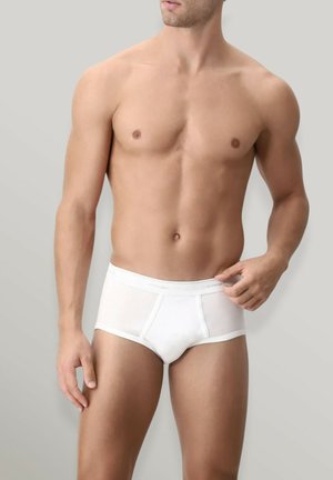 Slip di cotone bianco con un design aderente, caratterizzati da una fascia morbida e una texture liscia, esposti su un modello su uno sfondo grigio.