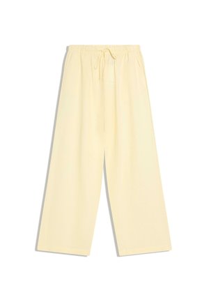 Loose, wide-leg pants in pale yellow with elastic waistband and adjustable drawstring, laid flat on a white background.