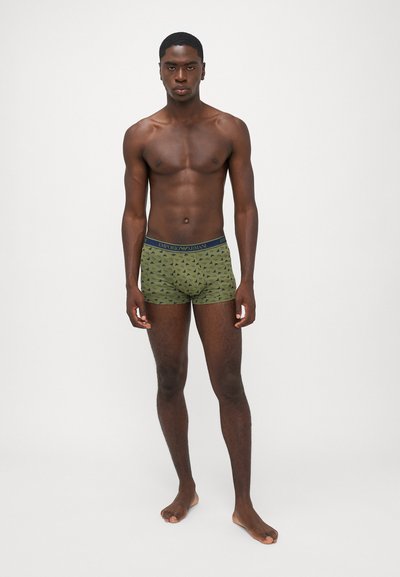 Boxers verts avec un petit motif géométrique, ornés d'une ceinture de marque bleu foncé. Le matériau semble doux et élastique.