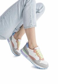 Sneakers bianchi e grigi con accenti pastello, sovrapposizioni texturizzate e una suola colorata. Presentano lacci neon e un mix di materiali.