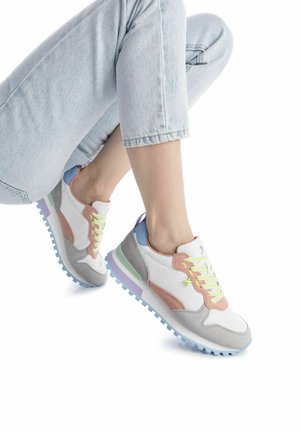 Zapatillas blancas y grises con acentos en tonos pastel, superposiciones texturizadas y una suela colorida. Presentan cordones neón y una mezcla de materiales.