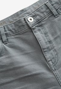 Pantaloni in cotone grigio con una texture liscia, dotati di chiusura a scatto in metallo, cuciture in evidenza e un classico design a cinque tasche.