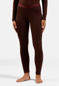 Brown thermal leggings with a contrasting waistband. Fitted design, stretchy material, and no visible patterns or logos. Barefoot model.