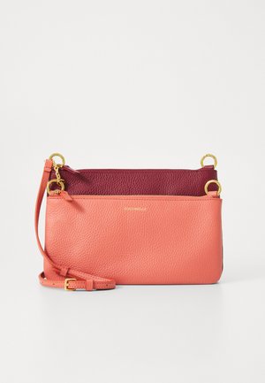 Dvi renkų odinė per petį nešama rankinė su koraline priekiu ir tamsiai raudonu užpakaliu, su auksinėmis detalėmis ir reguliuojama petneša, gulinčiu plokščiai ant baltos paviršiaus.