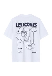 T-shirt blanc avec dessins au trait noir de cinq modèles de lampes modernes, accompagné du texte en gras "LES ICÔNES" et d'un texte plus petit lié à l'art et au design.