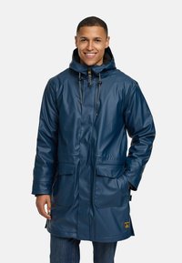 Marineblauwe waterdichte parka met een capuchon, voorzien van twee voorzakken en trekkoordsluitingen. Gladde, glanzende textuur, ontwerp tot op de heup.