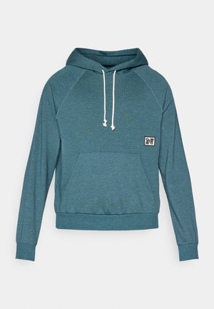 Tirkizna dukserica s kapuljačom na vezanje, prednjim kenguru džepom, rebrastim manžetama i donjim rubom, s malom brendiranom oznakom. Mekani materijal s blagom teksturom.