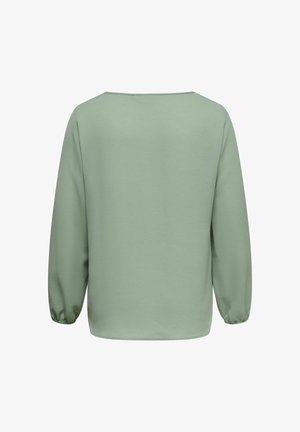 Roheline, tekstuuriga pika varrukaga pluus, mis on lõdva lõikega, laeva kaelusega ja kogutud mansettidega. Sile kangas, lihtne disain.