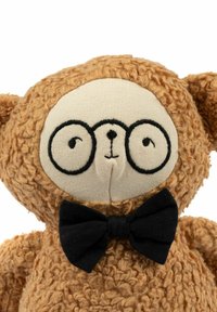 Ursuleț maro plușat cu blană texturată, față crem, ochelari rotunzi negri și papion negru. Ochii și nasul mic sunt brodați.