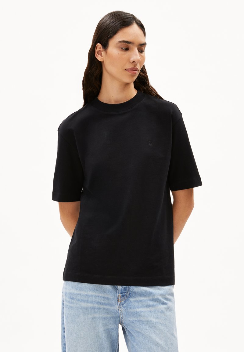 Zwarte katoenen T-shirt met een ronde hals, korte mouwen en een subtiele logodetail. De stof heeft een zachte textuur en een ontspannen pasvorm.